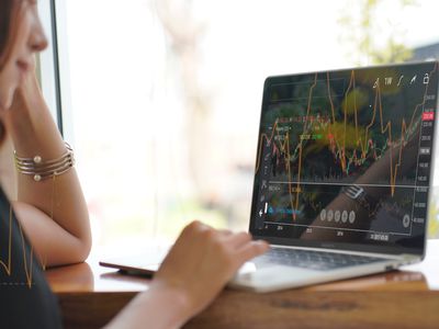 Woman looking at a stock market graph on a monitor screen