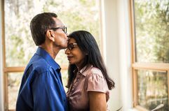 Senior man kissing wife at home