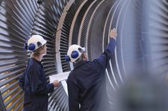 Engineers, representing operating expenses (OpEx), work on a turbine, representing capital expenditures (CapEx).