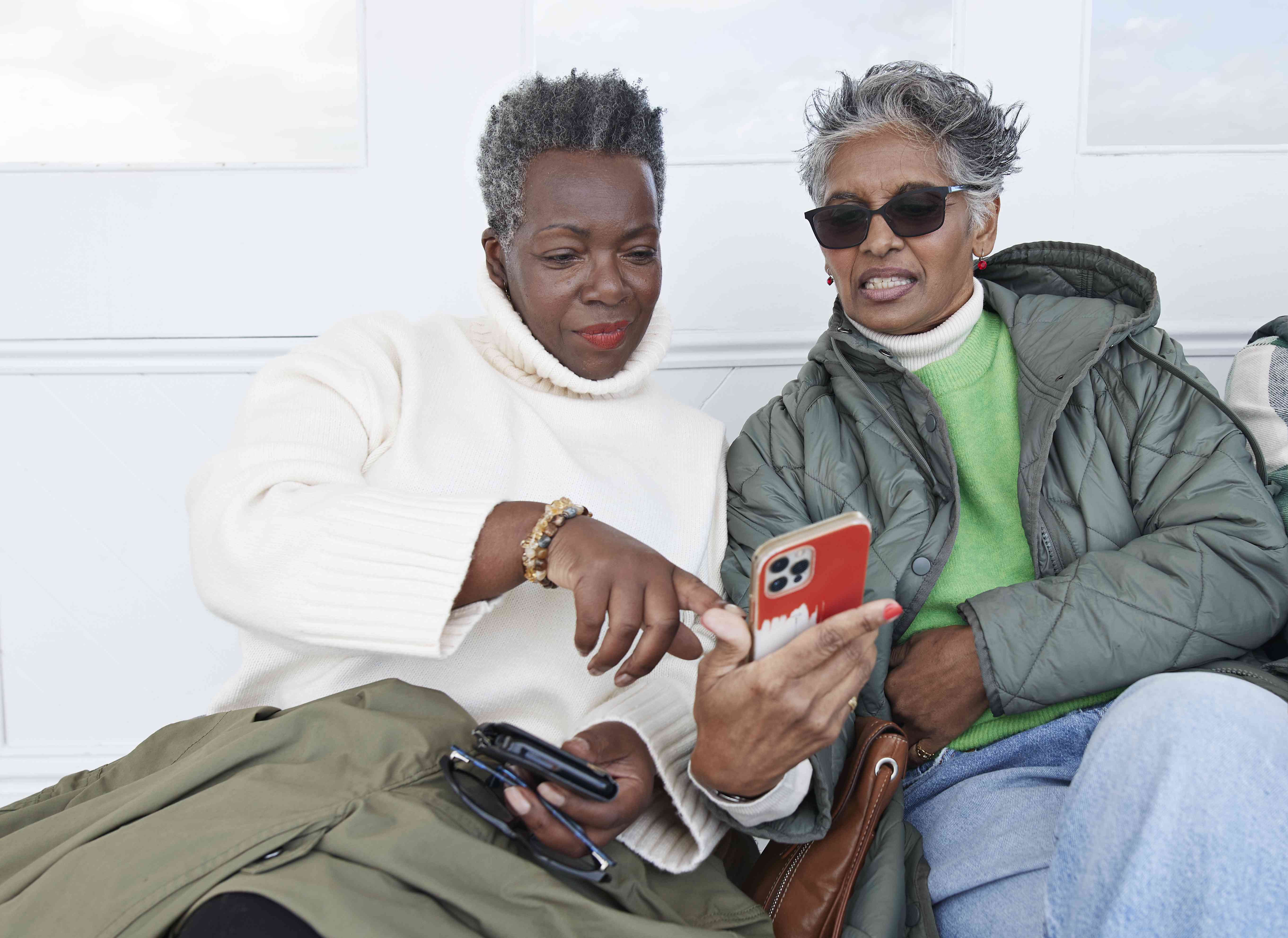 Two older women look at smartphone