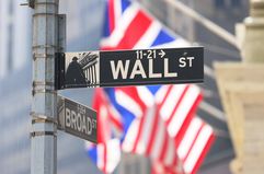 A Wall Street street sign appears in front of the New York Stock Exchange