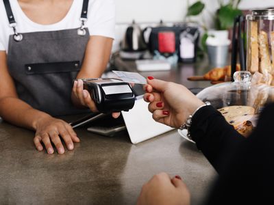 Woman Hand Holding Credit Card While Making Payment In Cafe