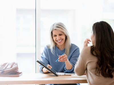 Female financial advisor showing her client something on a tablet.