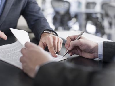 Businessman showing client where to sign document