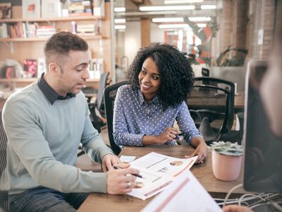 Man and woman looking over a spreadsheet in an office setting