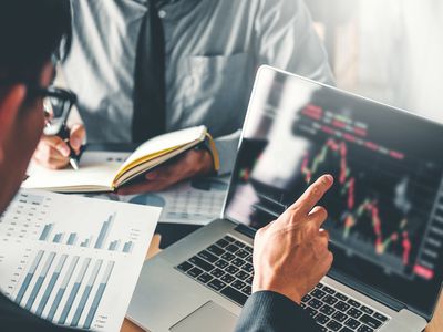 Midsection Businessmen Analyzing Charts on Laptop in Office