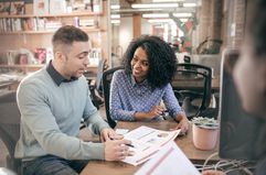 Man and woman looking over a spreadsheet in an office setting