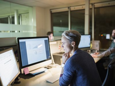 Businesswoman working late at computers in office