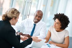 Shot of a young couple meeting with a financial planner in a modern office