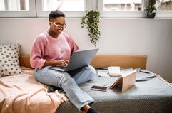 Person with spectacles working on a laptop