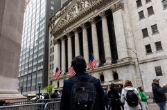 Pedestrians walk along Wall Street near the New York Stock Exchange (NYSE) in New York, US, on Thursday, May 16, 2024.