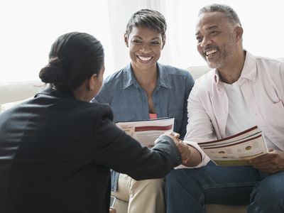 Middle-aged African American couple discussing retirement plans with financial advisor.