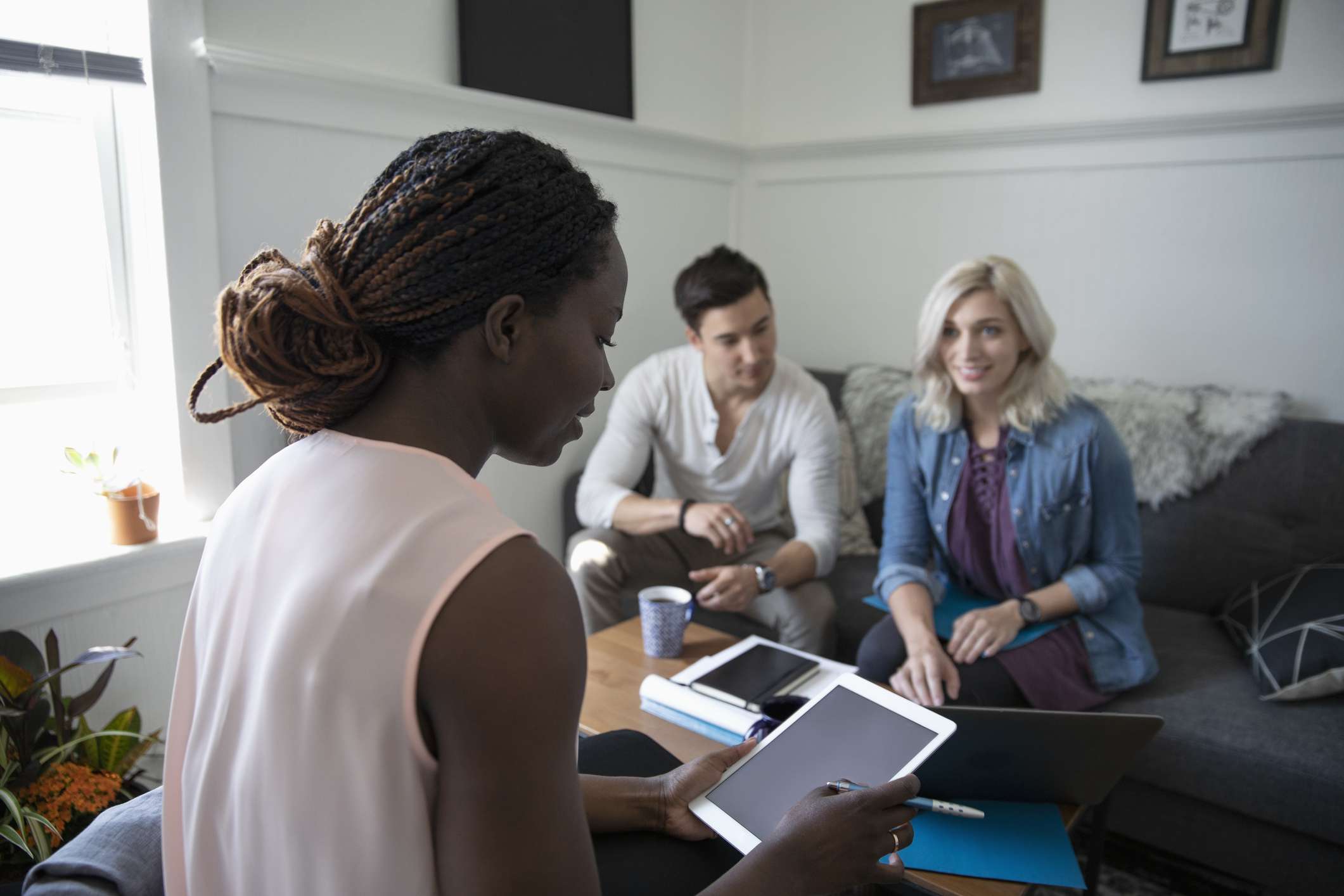 Financial advisor consulting with young couple in living room