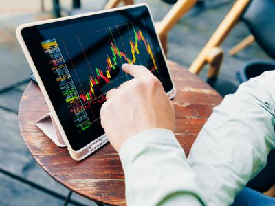 Men's hands and a trading chart on a digital tablet