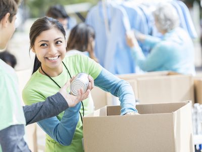 A woman passing out canned goods