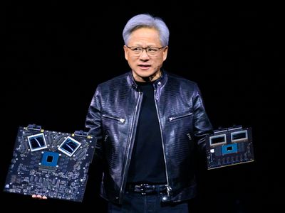 CEO Jensen Huang holds two Nvidia products while speaking on stage 