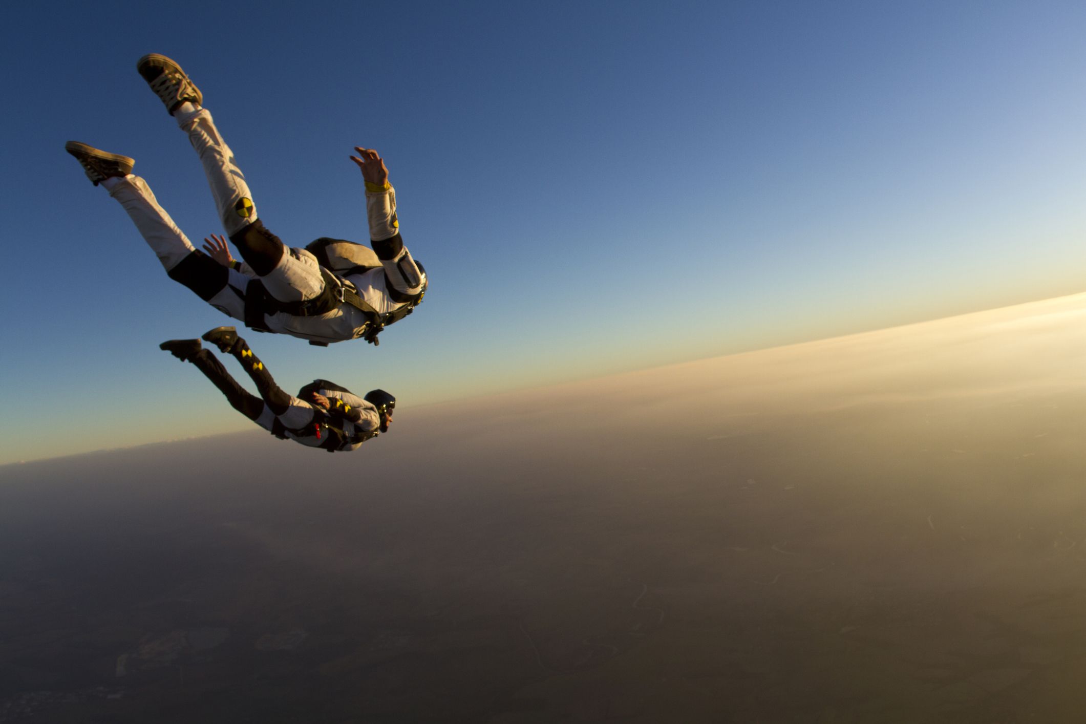 Two people skydiving at sunset