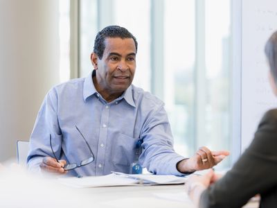 businessman gestures as he asks the financial advisor a question