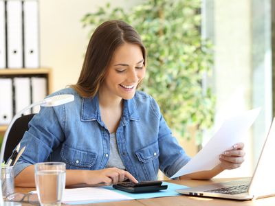 A woman calculating a budget on a desktop at office