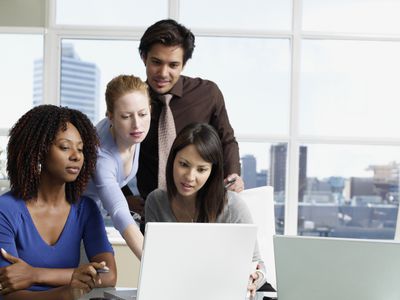 Business people in an office looking at a laptop