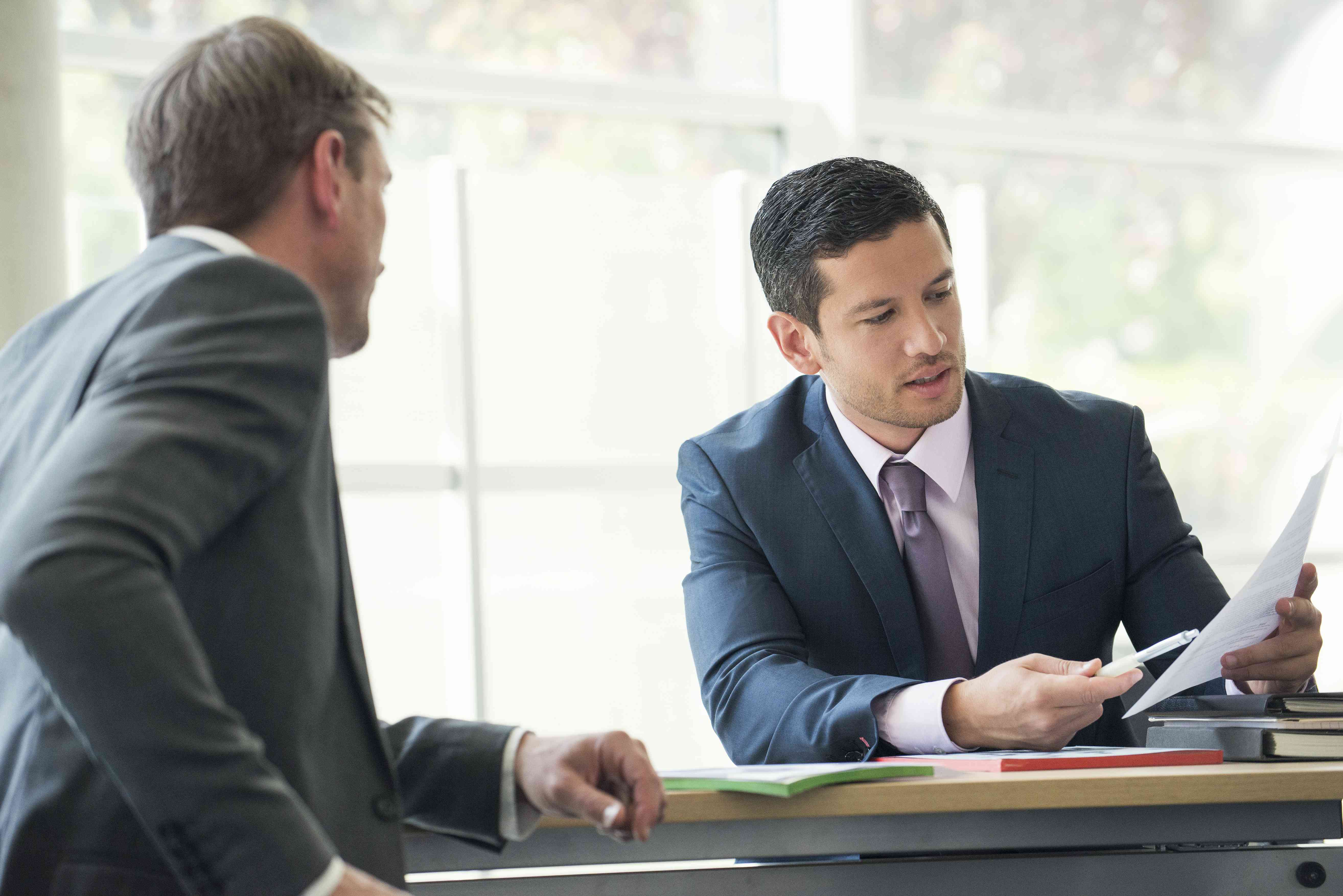 Businessmen discussing contract in meeting