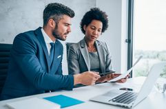 Two people discussing paperwork at a meeting table