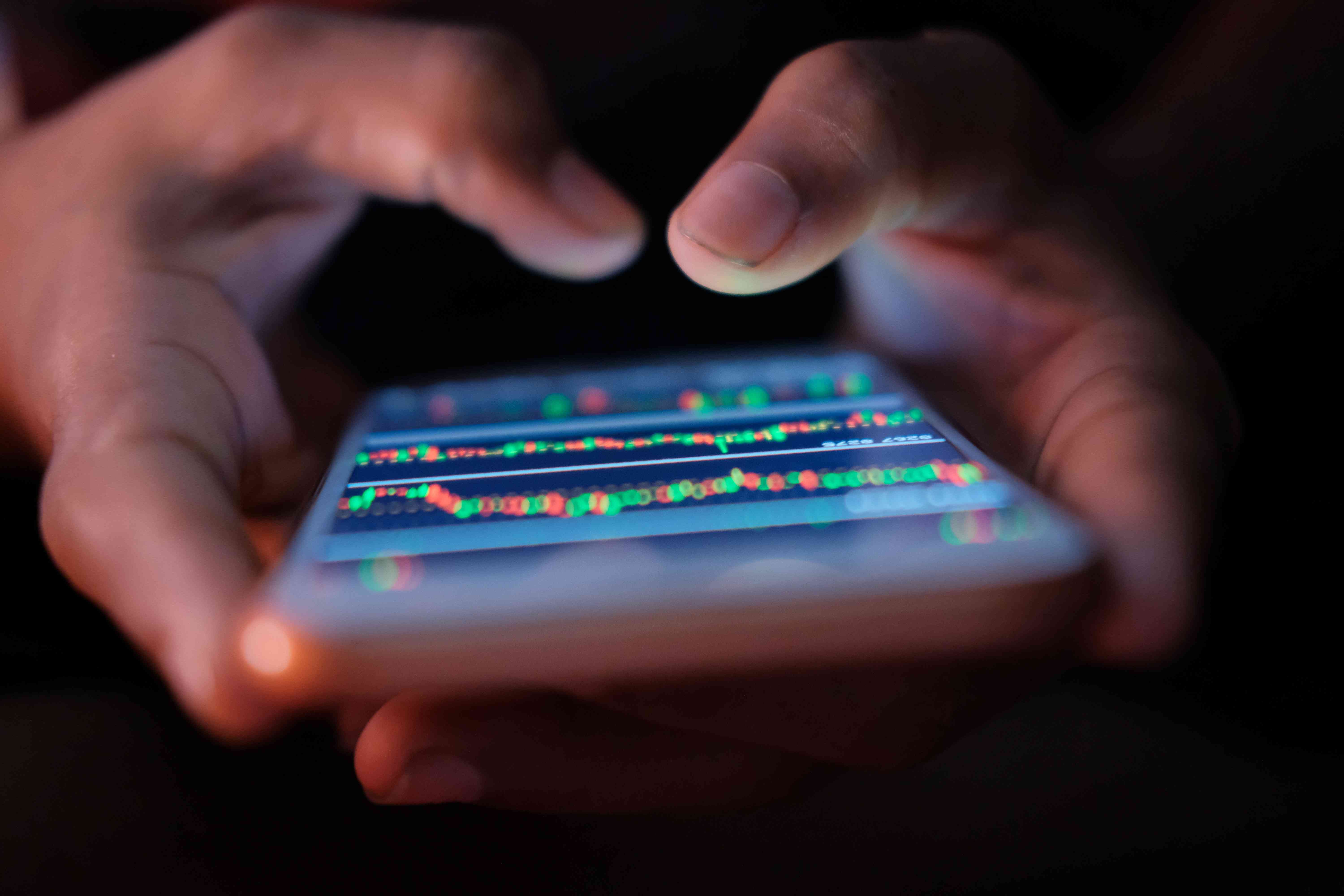 Young man hand analyzing stock market data on phone