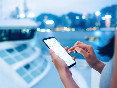 Woman Checking Stocks and Shares Data With Smartphone in City