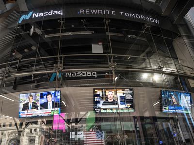 The Nasdaq building with TV screens displaying financial news