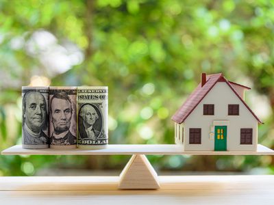 Home loan / reverse mortgage or transforming assets into cash concept : House model, US dollar notes on a simple balance scale, depicts a homeowner or a borrower turns properties / residence into cash