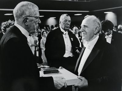 Russian born Simon S. Kuznets, (right) of Harvard University accepts his Nobel Prize in Economics from Sweden's King Gustav Adolf in a Pentecostal church rented for the occasion.