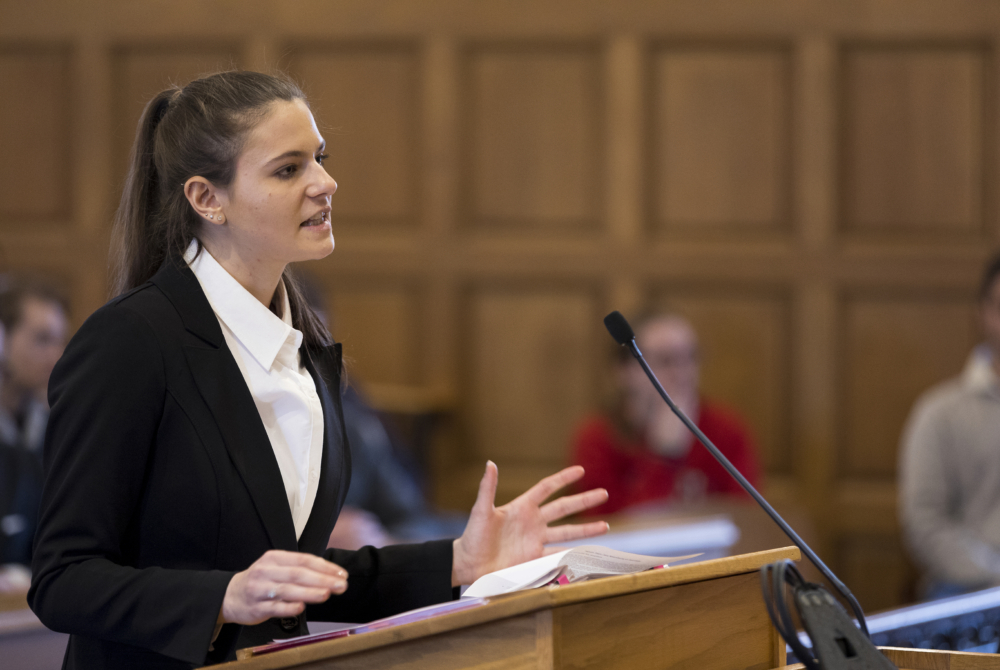 woman at a podium speaking into a microphone