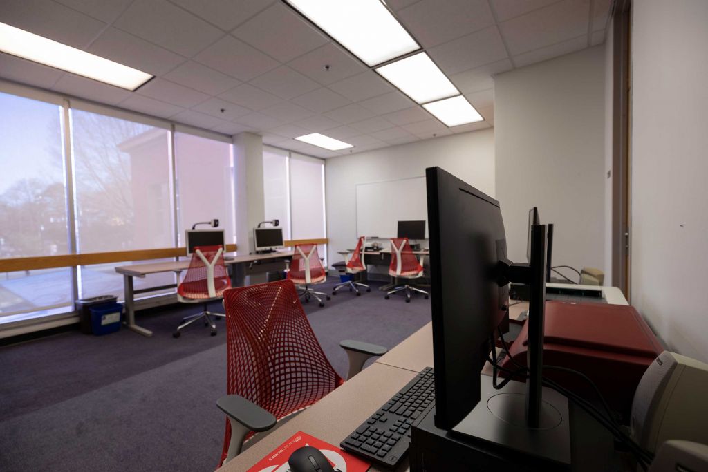 Hill Assistive Technologies Center with multiple workstations equipped with magnification cameras, microforms scanner, braille printers, and other equipment with floor to ceiling windows overlooking Hillsborough Street.