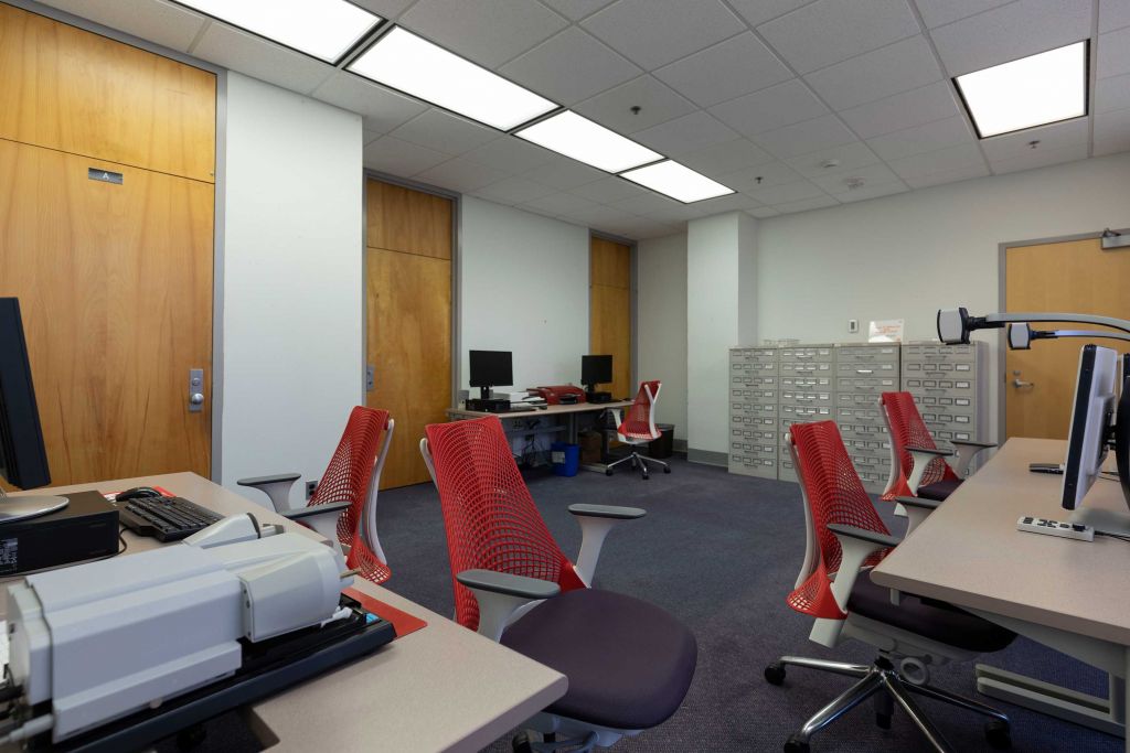 Hill Assistive Technologies Center with multiple workstations equipped with magnification cameras, microforms scanner, braille printers, and other equipment. It also houses cabinets of microform.