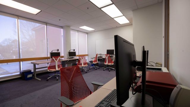 Hill Assistive Technologies Center with multiple workstations equipped with magnification cameras, microforms scanner, braille printers, and other equipment with floor to ceiling windows overlooking Hillsborough Street.