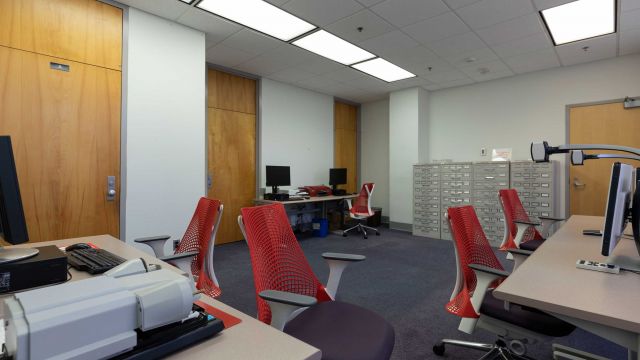 Hill Assistive Technologies Center with multiple workstations equipped with magnification cameras, microforms scanner, braille printers, and other equipment. It also houses cabinets of microform.