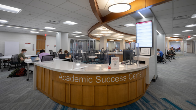 Curved wooden desk with a sign, Academic Success Center