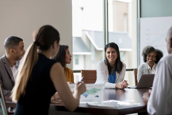 Men and women sit around a conference table in a nonprofit boardroom