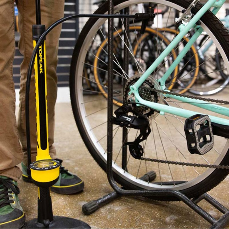 Close-up of a bike tire being pumped with air.