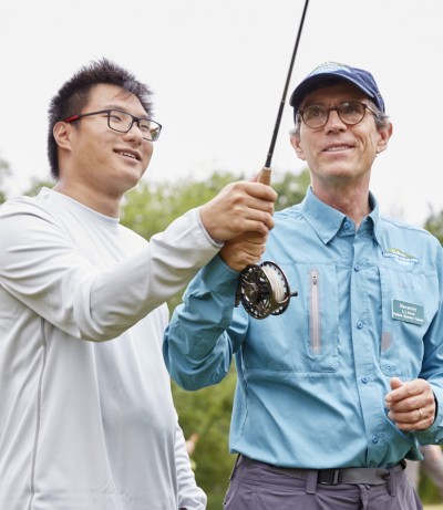 A young man learning to fly fish