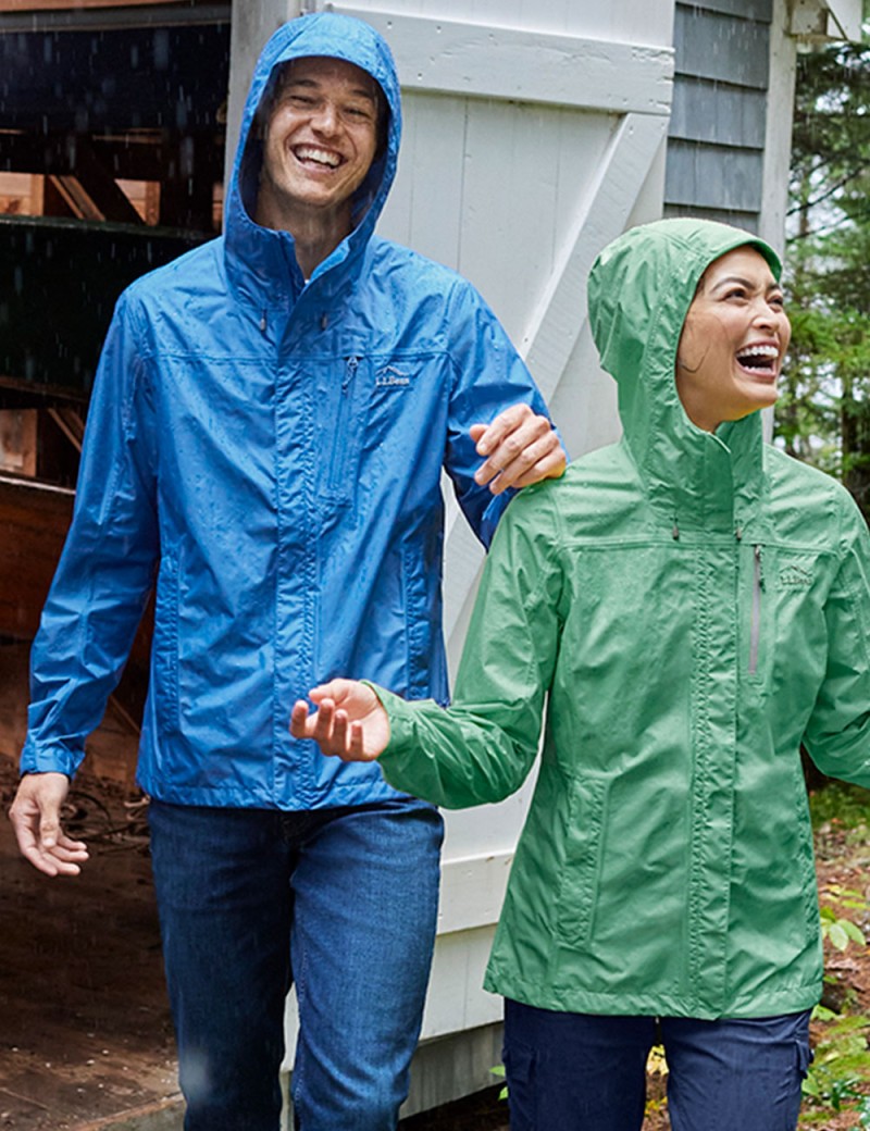 A smiling couple outside in the rain.