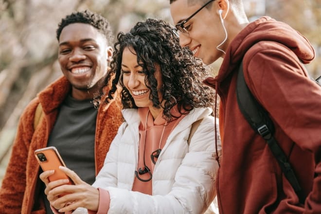 Amigos mirando un teléfono inteligente - mejores retos para chicos