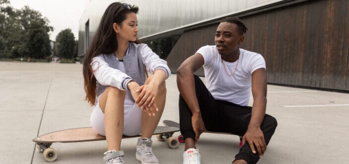 hombre y mujer sentados en sus patinetas compartiendo pensamientos