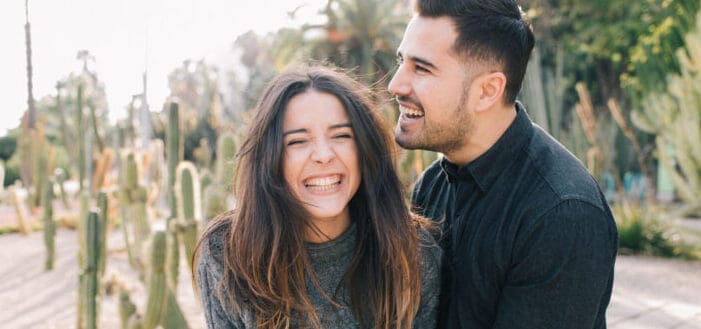 Pareja disfrutando de una risa íntima en un jardín de cactus