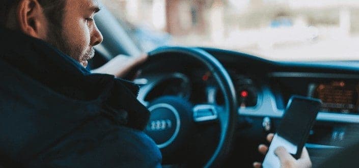 man using phone inside his car