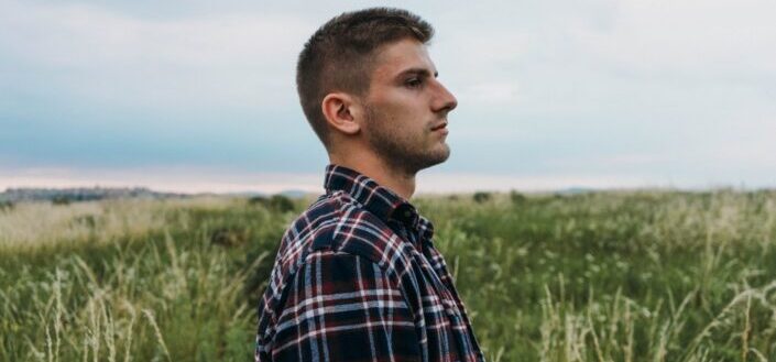 man-standing-on-grass-field-