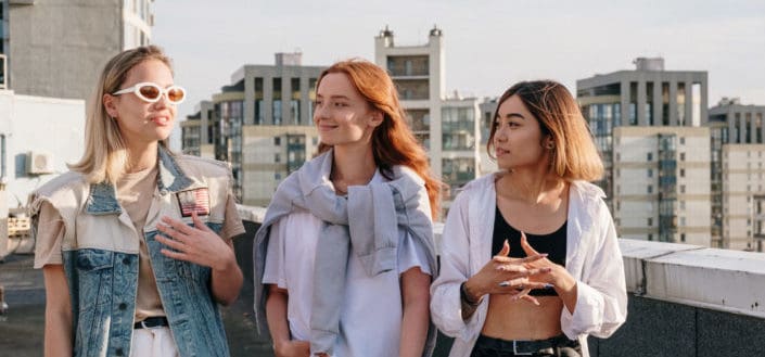 tres mujeres pasando tiempo en la azotea de un edificio