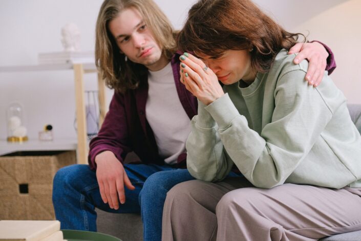 man-comforting-crying-sorrowful-woman-with-hands-together-