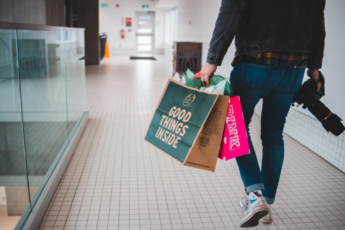 una persona con bolsas de compras y una cámara