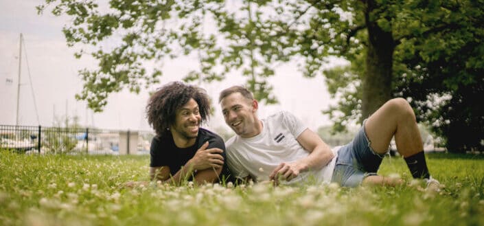 Hombres sonrientes tirados en la hierba